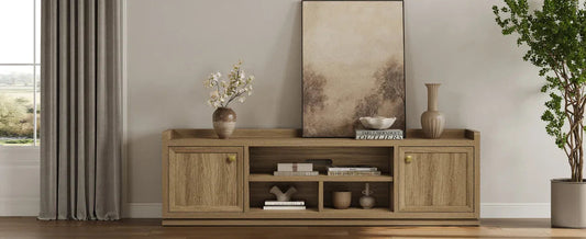 Modern living room with wooden TV stand, decorative vases, books, abstract art, and green plant