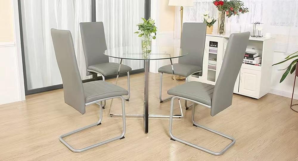 Modern dining room with glass table and four gray upholstered dining chairs