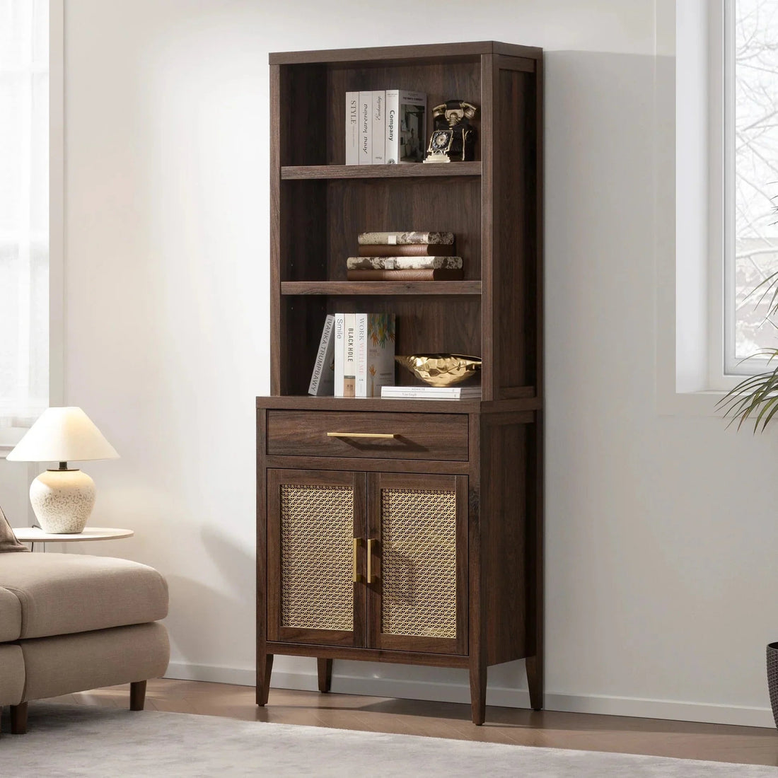 Tall wooden bookcase with rattan cabinet doors, books, and decor in a modern living room