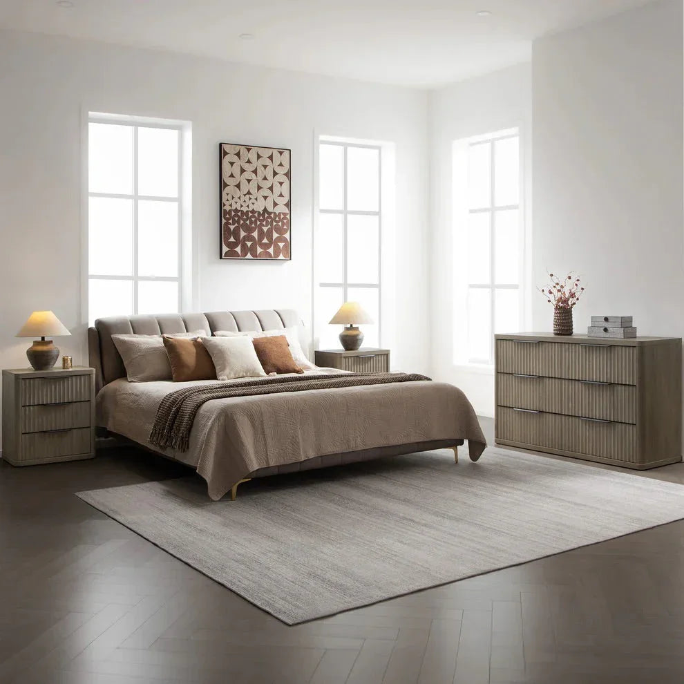 Modern bedroom with upholstered bed, neutral bedding, wooden nightstands, and dresser