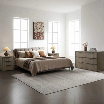 Modern bedroom with upholstered bed, neutral bedding, wooden nightstands, and dresser