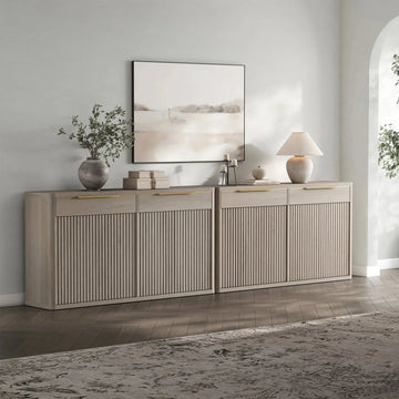 Modern fluted oak sideboard with decor, table lamp, and abstract art in a contemporary living room.
