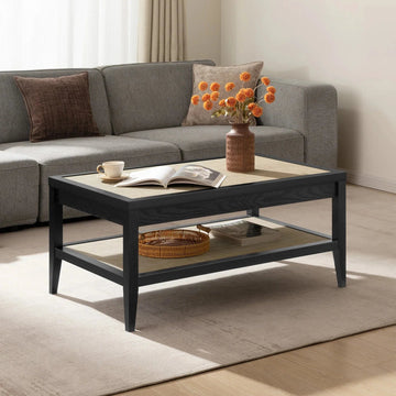 Modern living room with a gray sofa and a black Savanna coffee table, vase of orange flowers