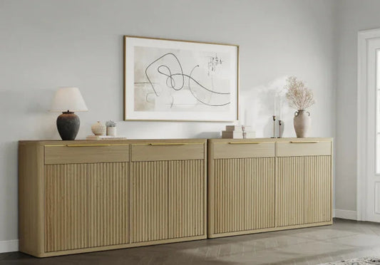 Modern light wood sideboard with lamp, decor vases, and abstract wall art in a minimalist room