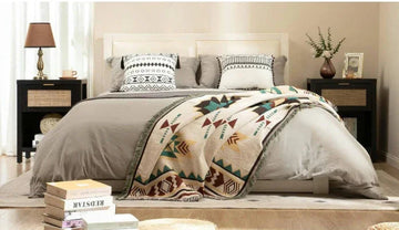 Modern bedroom with geometric bedding, decorative pillows, and bedside tables