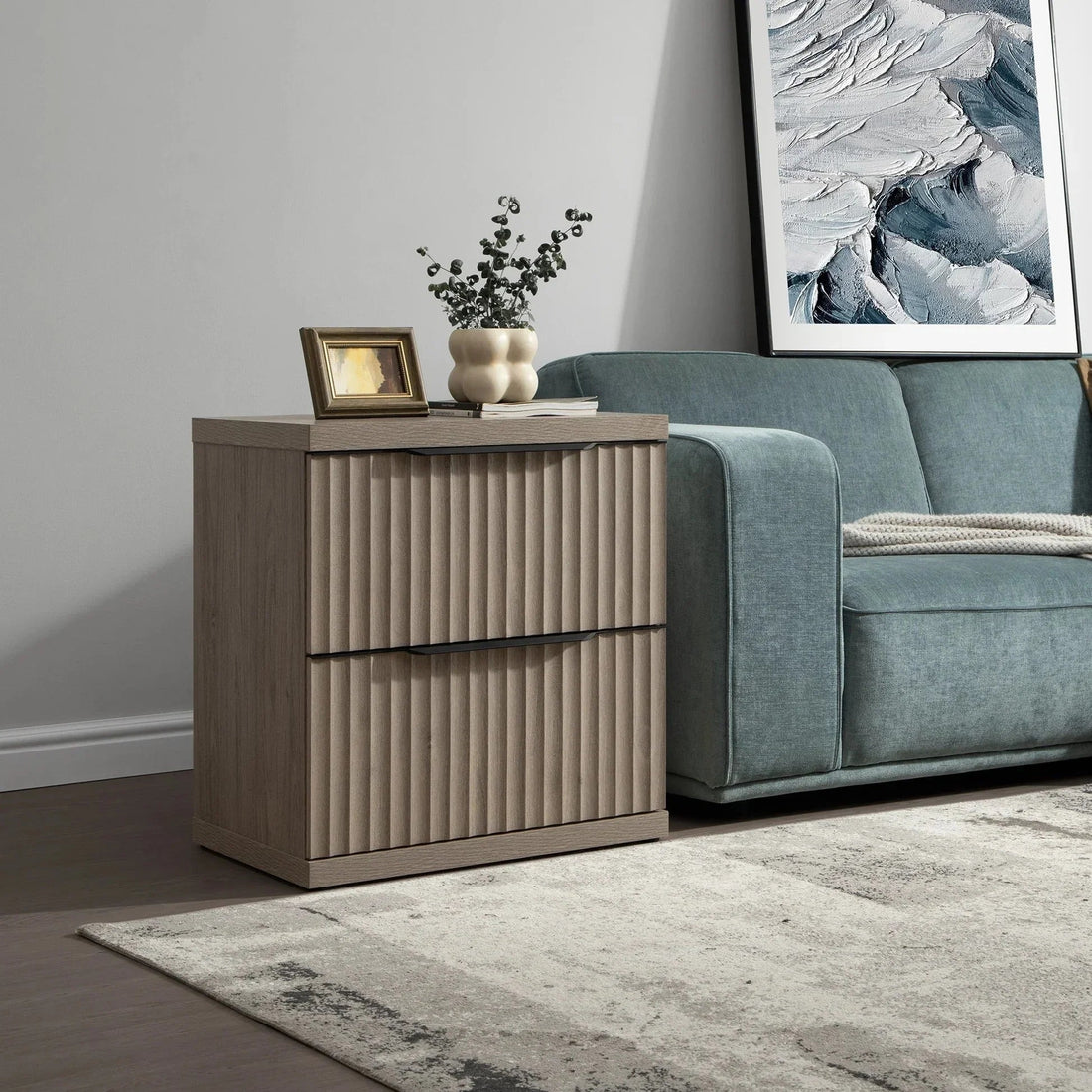 Modern wood nightstand with vertical grooves beside a teal sofa in living room setting