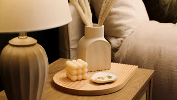 Modern wood nightstand with lamp, ceramic vase, bubble candle, and jewelry tray decor