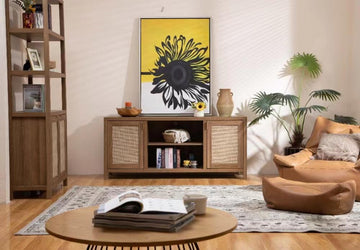 Modern living room with yellow sunflower artwork, wooden furniture, indoor plants, and leather lounge chair.