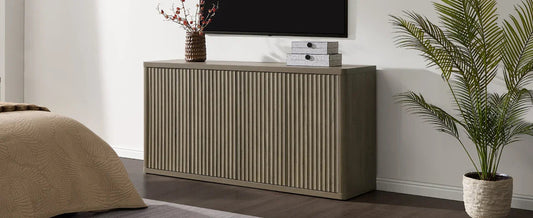 Modern bedroom with ribbed wood sideboard, wall-mounted TV, potted plant, and decor boxes.