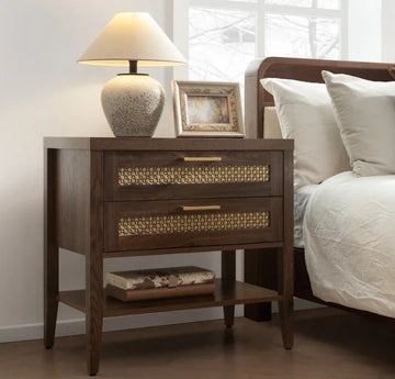 Modern wooden nightstand with brass accents, table lamp, picture frame, and decor, beside bed