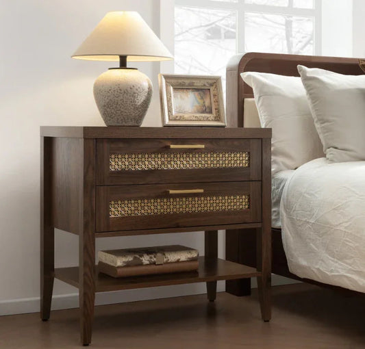 Modern wooden nightstand with brass accents, table lamp, picture frame, and decor, beside bed
