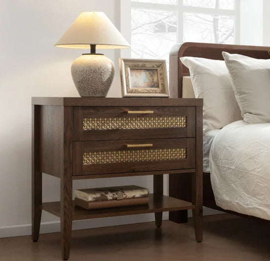 Wood nightstand with two drawers, gold geometric pattern, table lamp, photo frame, and book
