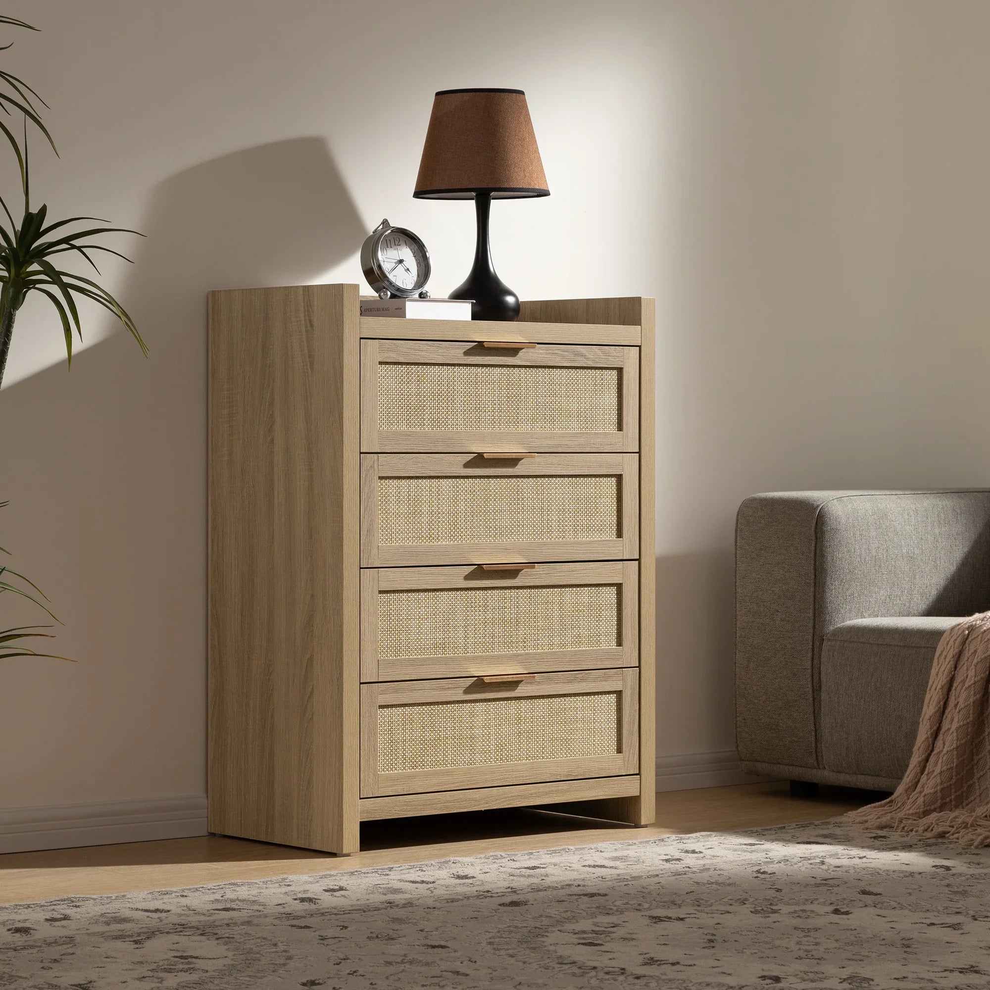 Modern wooden chest of drawers with rattan fronts, lamp, and clock in cozy living room corner