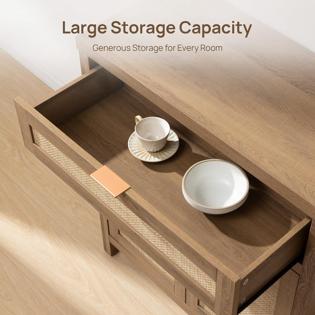 Wooden storage cabinet with large open drawer, cup and bowl on top, light wood floor