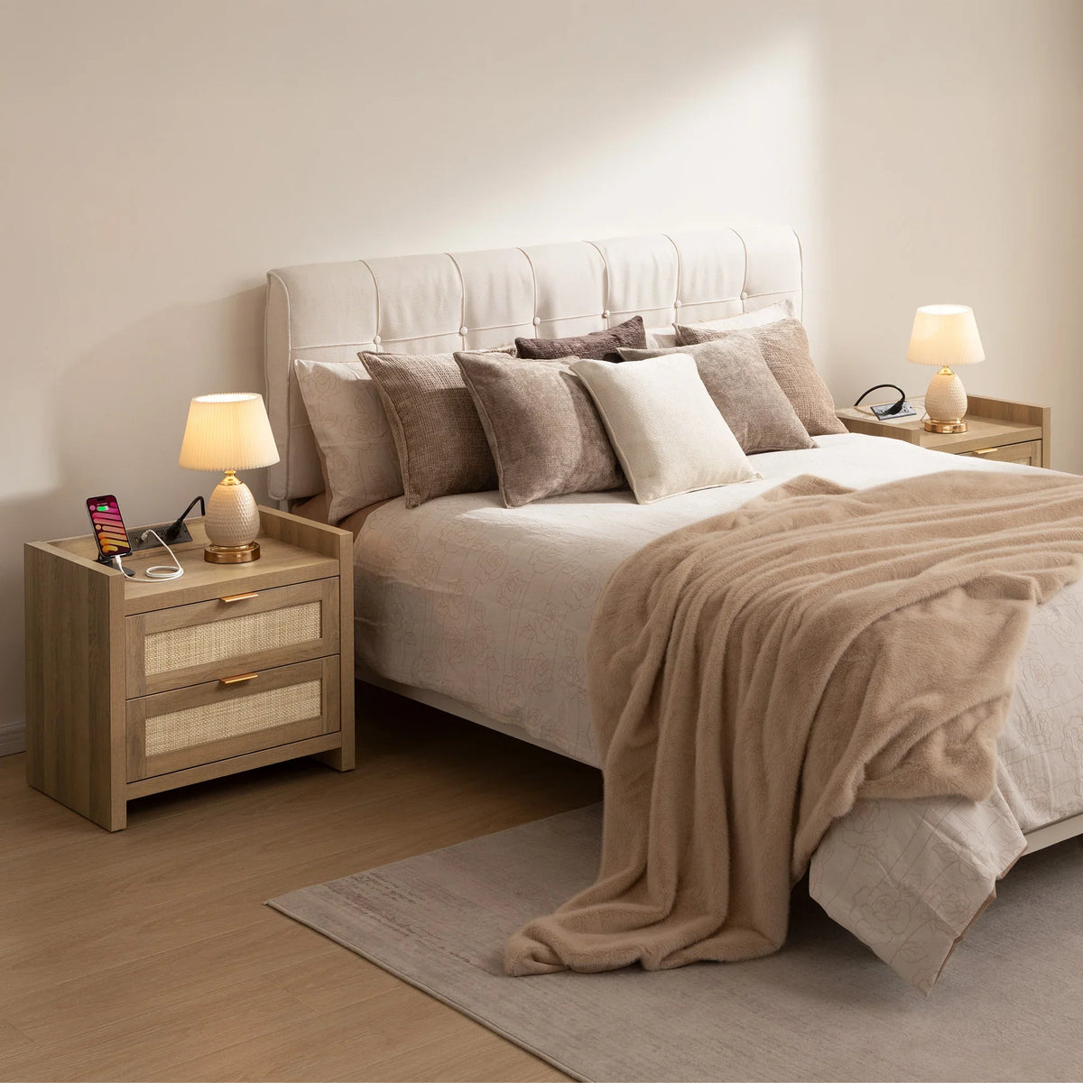 Modern bedroom with upholstered bed, neutral pillows, beige blanket, wooden nightstands, and lamps