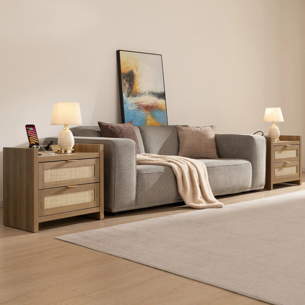 Modern living room with gray sofa, abstract wall art, wood side tables, and table lamps