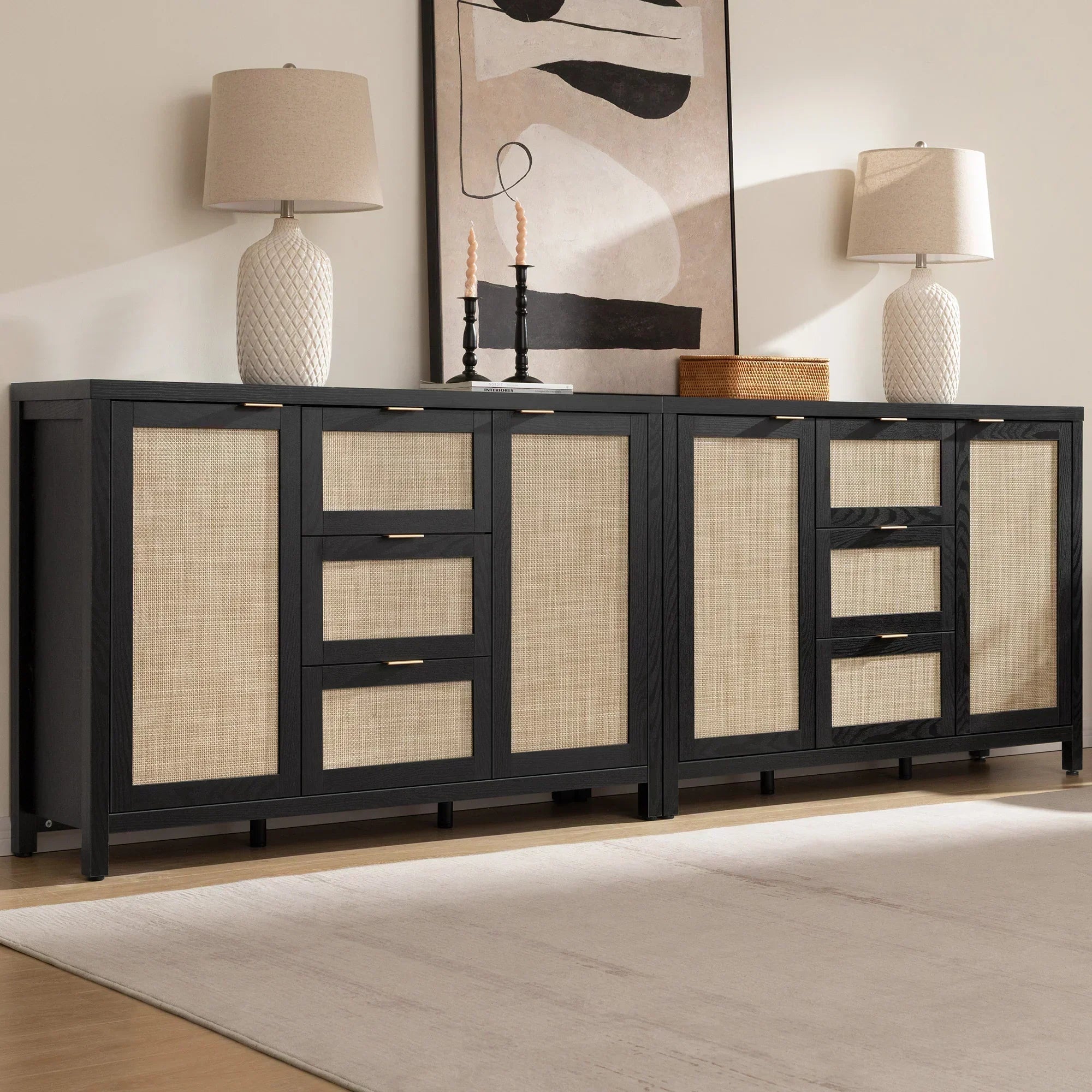 Modern black and rattan sideboard with lamps, abstract wall art, and beige area rug
