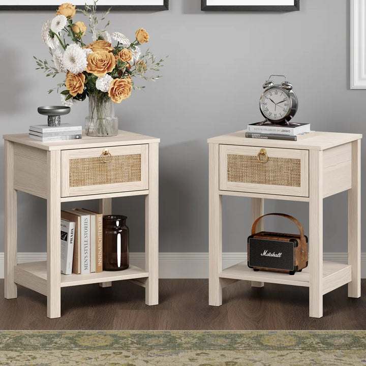 Pair of light wood nightstands with rattan drawers, books, vase of flowers, and decor accents