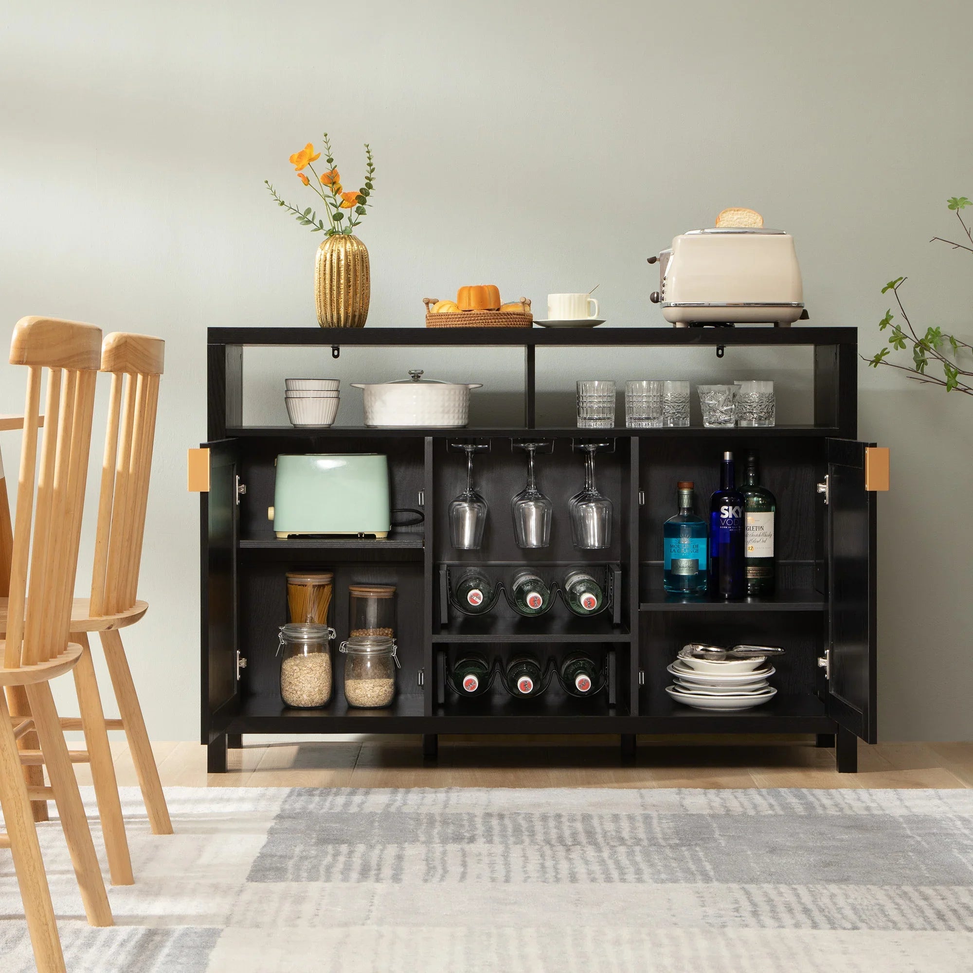 Modern black sideboard with glassware, bottles, toaster, vase, and kitchen essentials
