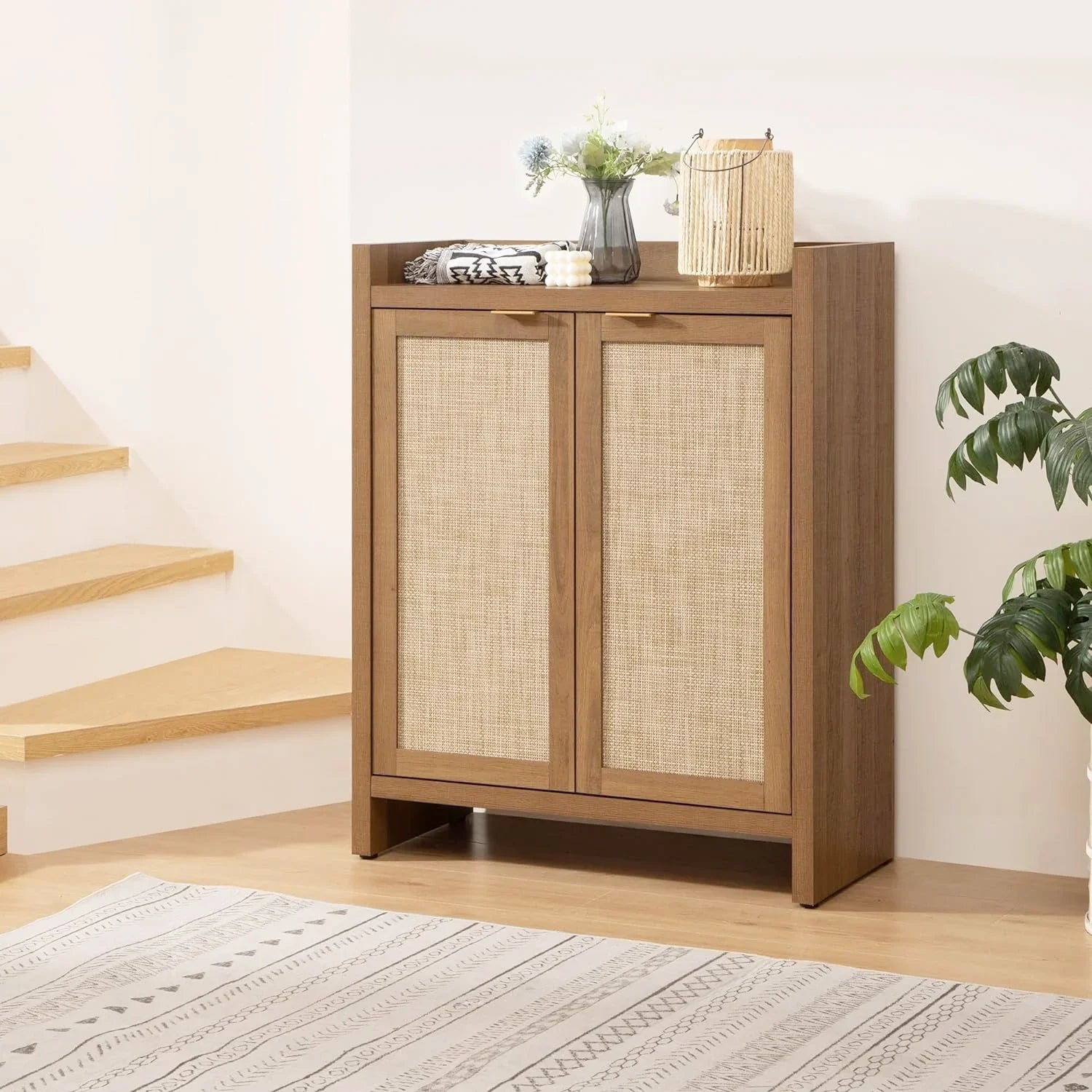 Modern wooden storage cabinet with woven rattan doors, decor, and plant in a bright room