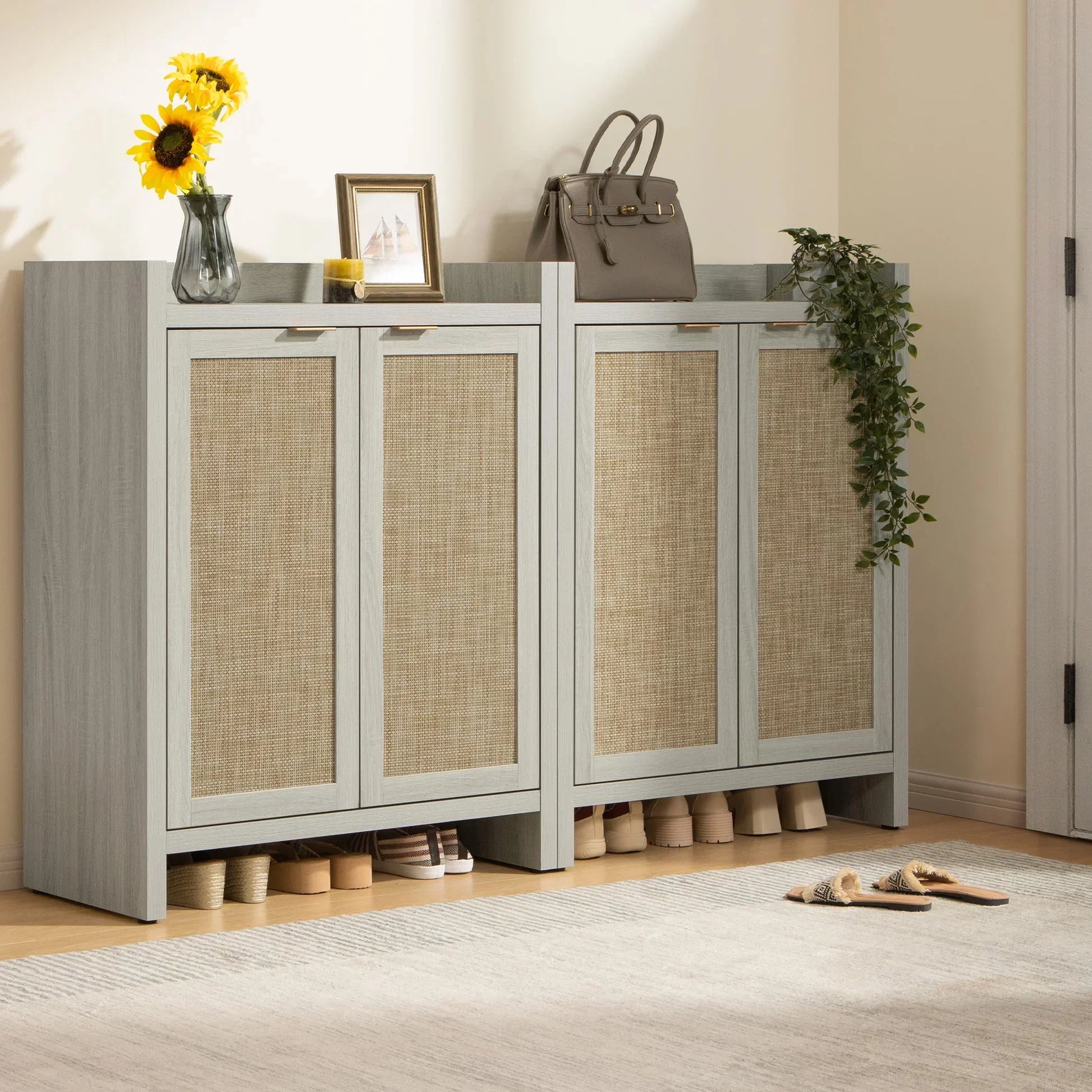 Entryway with light wood shoe cabinet, rattan doors, sunflowers in vase, purse, and shoes underneath