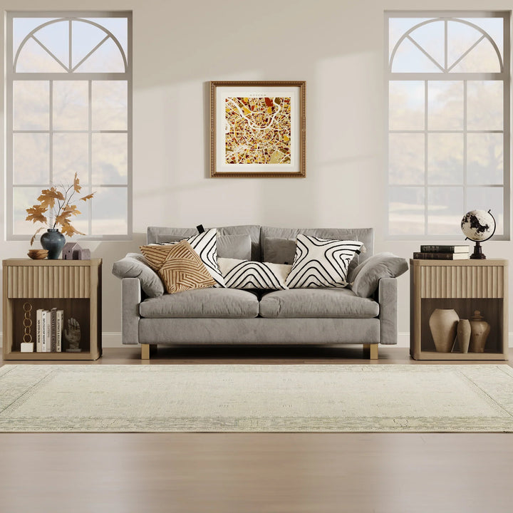 Modern living room with gray sofa, patterned pillows, abstract wall art, and large windows.