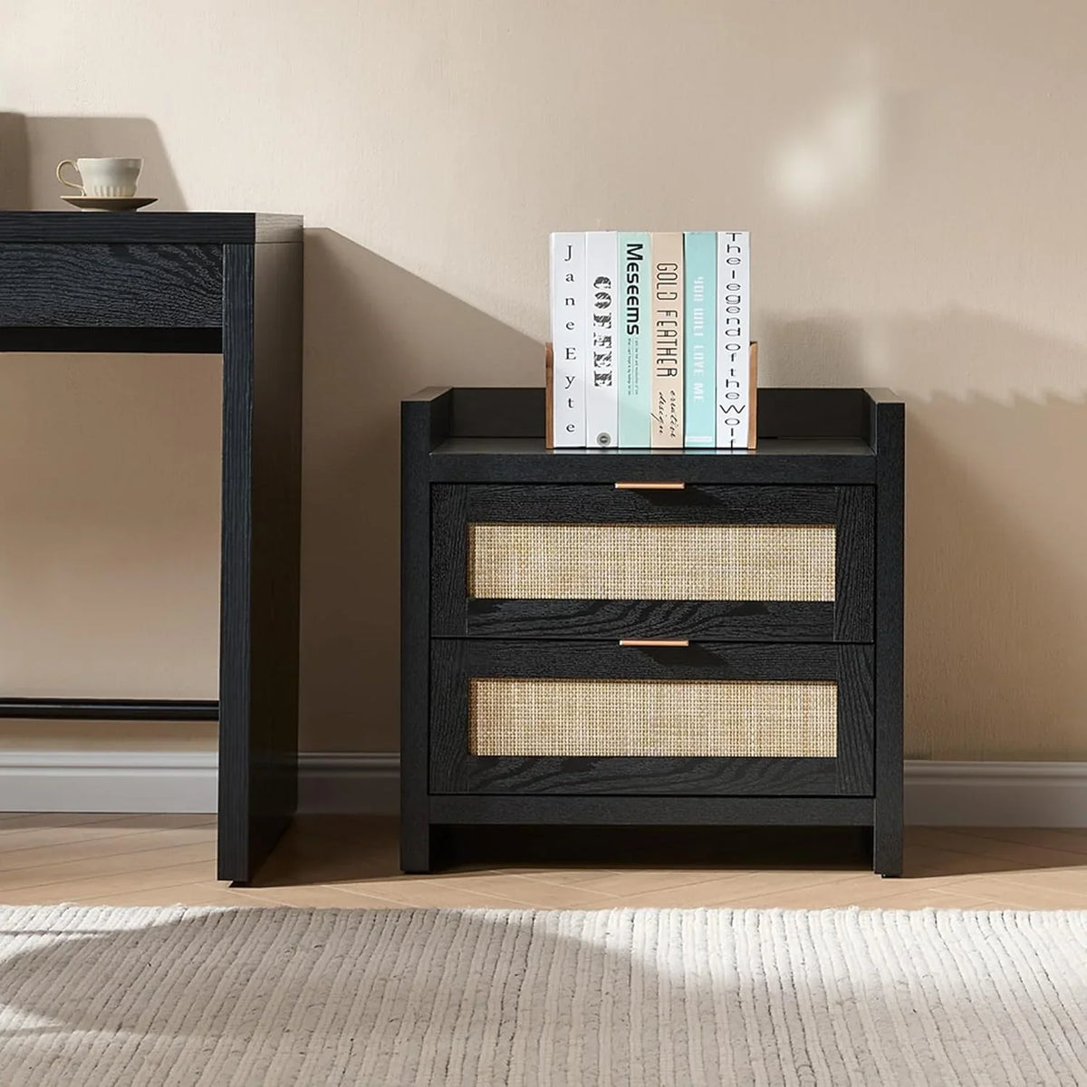 Modern black nightstand with two woven drawers, books on top, in a minimalist bedroom