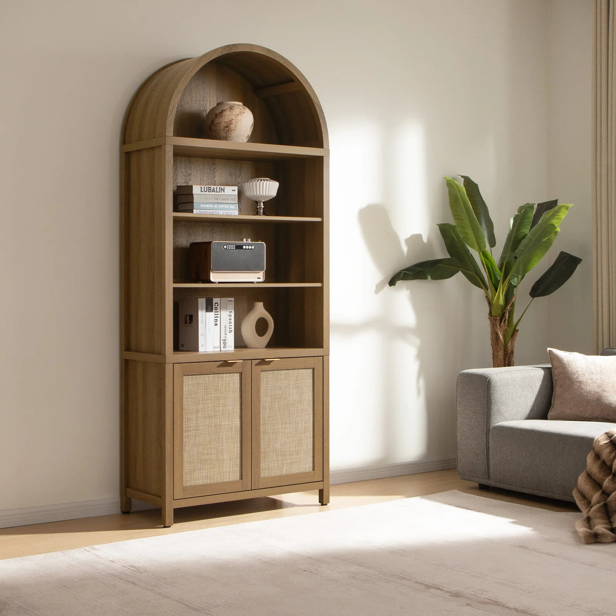 Modern living room with arched wooden bookshelf, gray sofa, potted plant, and neutral decor