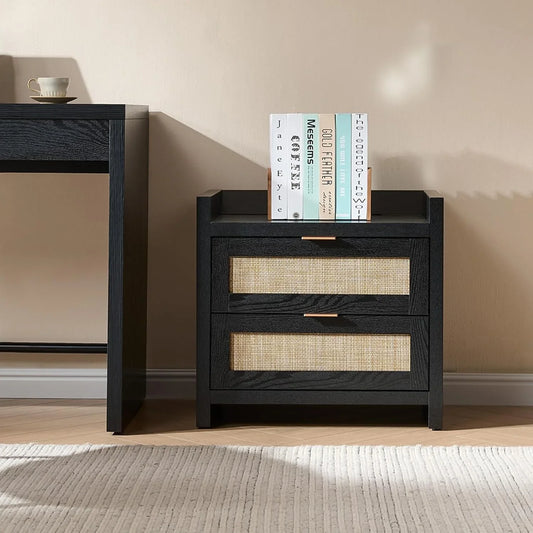 Black nightstand with rattan drawers and books on top, next to a cup on a modern desk