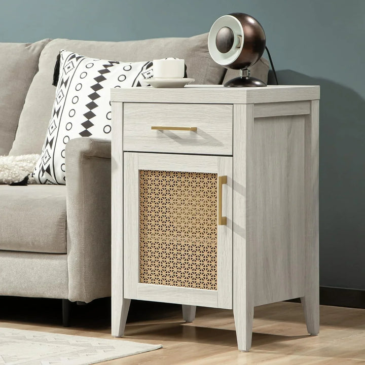 Light wood nightstand with rattan door panel, black lamp, and white sofa in modern living room