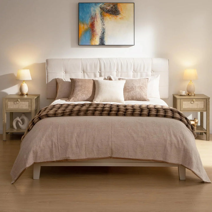 Modern bedroom with upholstered bed, neutral bedding, abstract wall art, and bedside tables