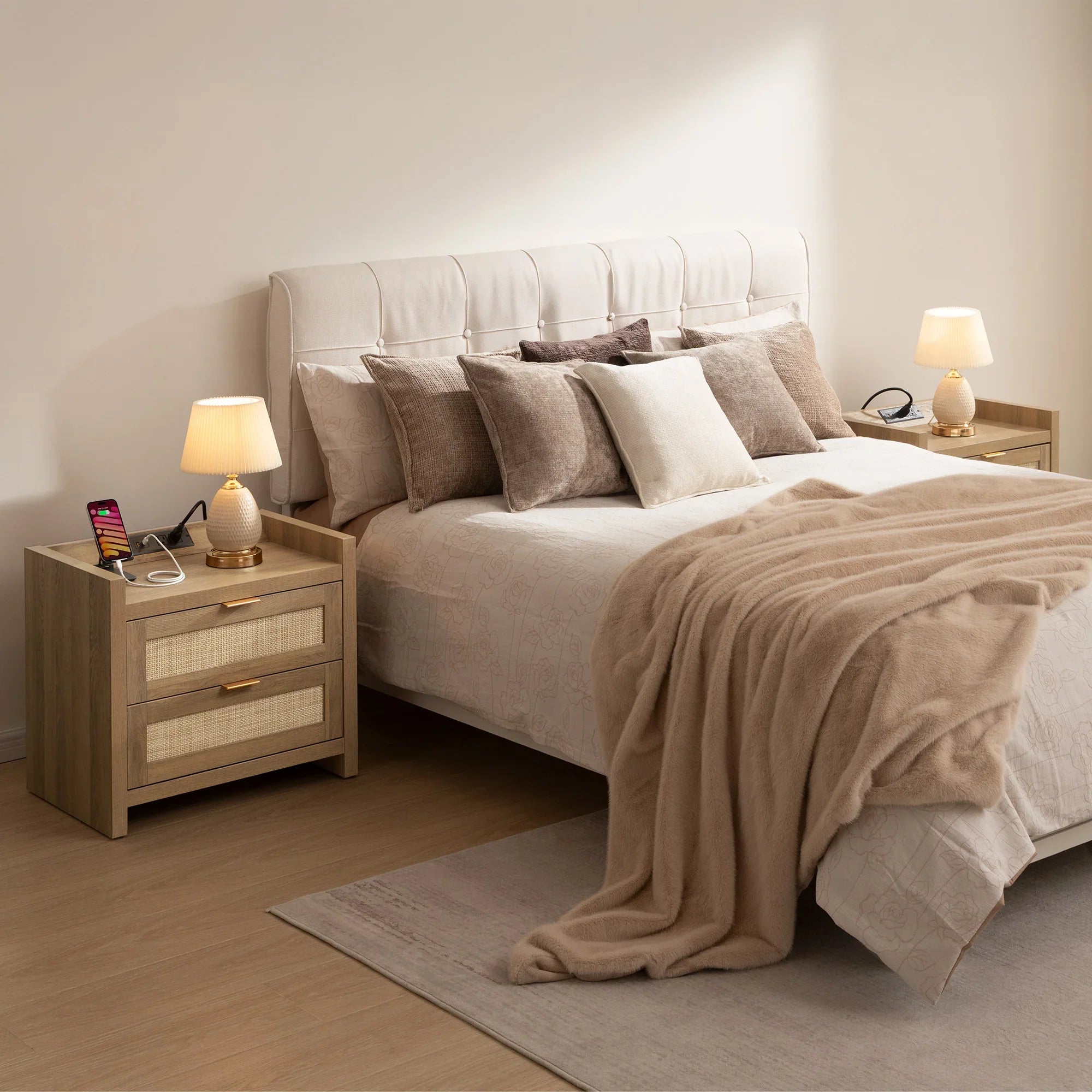 Modern bedroom with beige bed, multiple pillows, nightstands, lamps, and cozy throw blanket