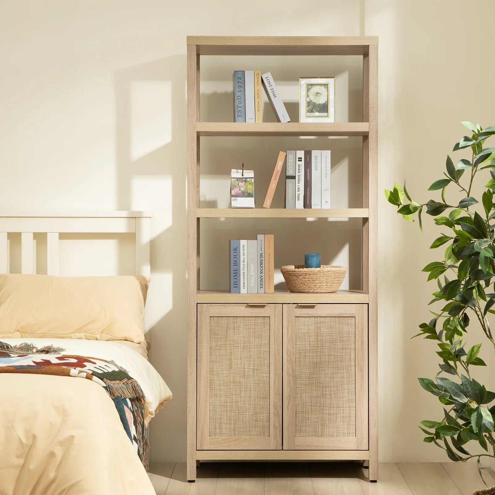 Modern light wood bookcase with books, decor, and basket beside beige bed and houseplant