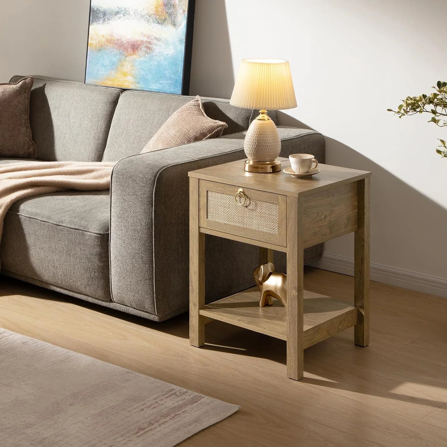 Modern living room with grey sofa, wooden side table, lamp, and abstract wall art