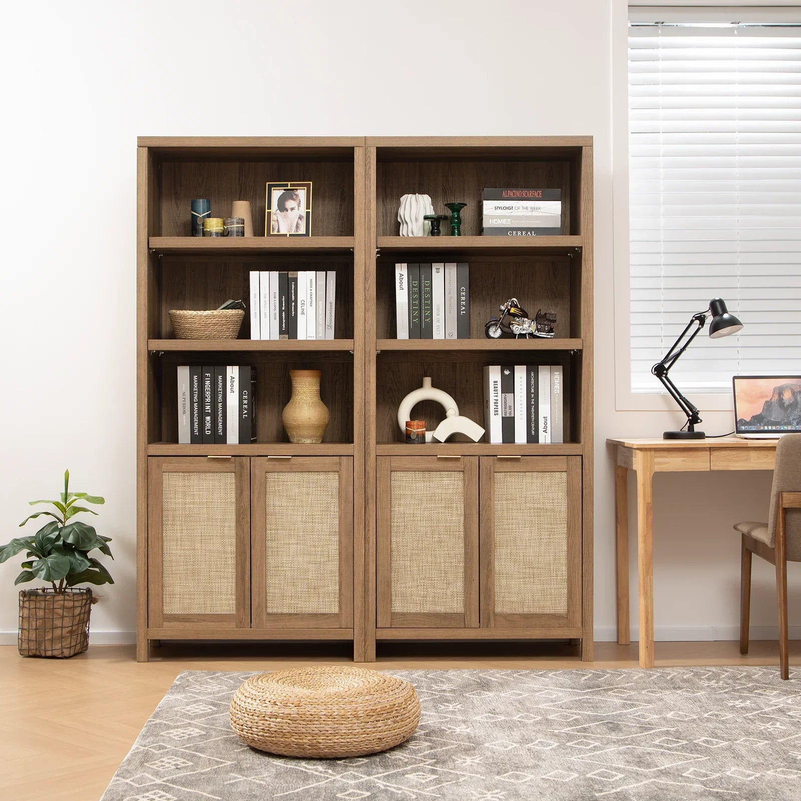 Modern wooden bookshelf with decor, books, and rattan doors beside a home office desk