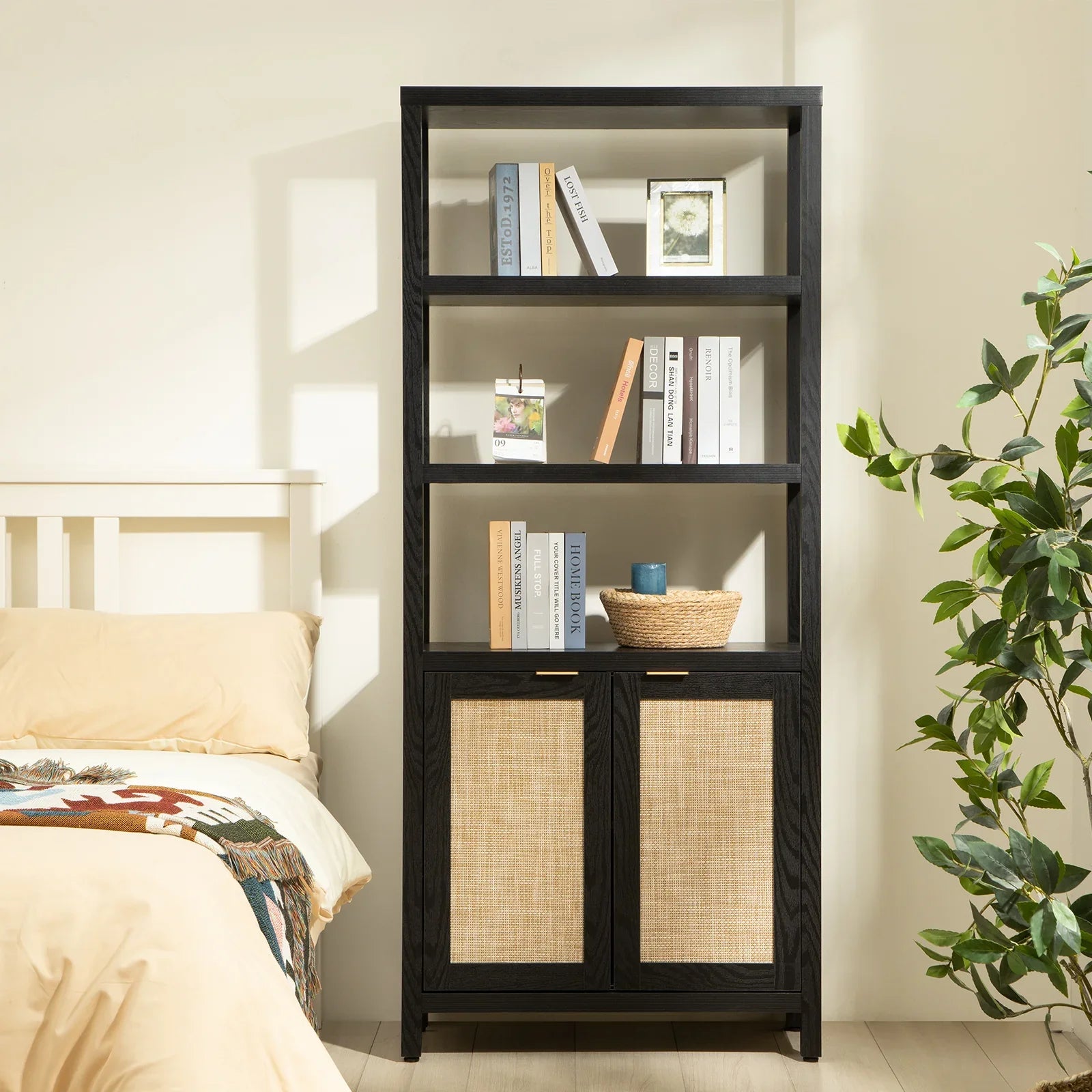 Modern black wood bookshelf with rattan doors in a cozy bedroom with books and decor