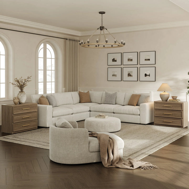 Modern living room with cream sectional sofa, round chair, wood side tables, and neutral decor