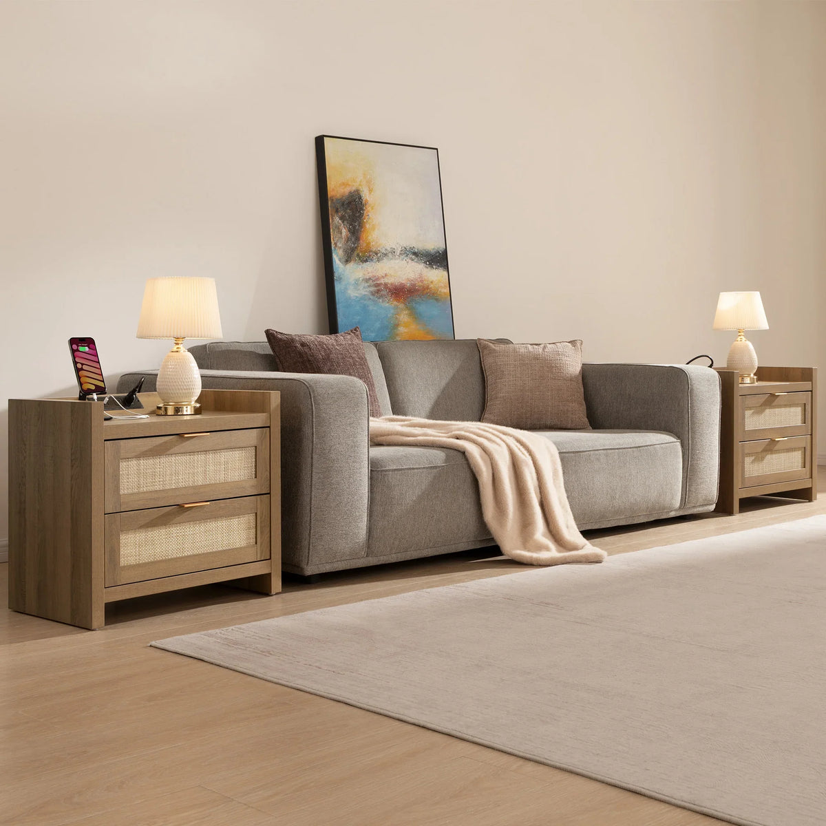 Modern living room with gray sofa, wooden side tables, table lamps, and abstract wall art