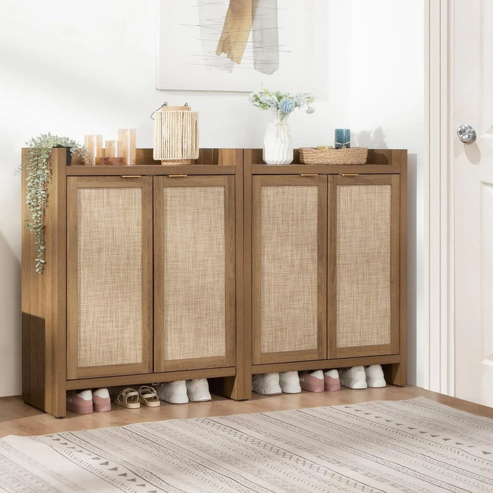 Modern rattan shoe cabinet with decor, shoes stored underneath, in a bright entryway corner