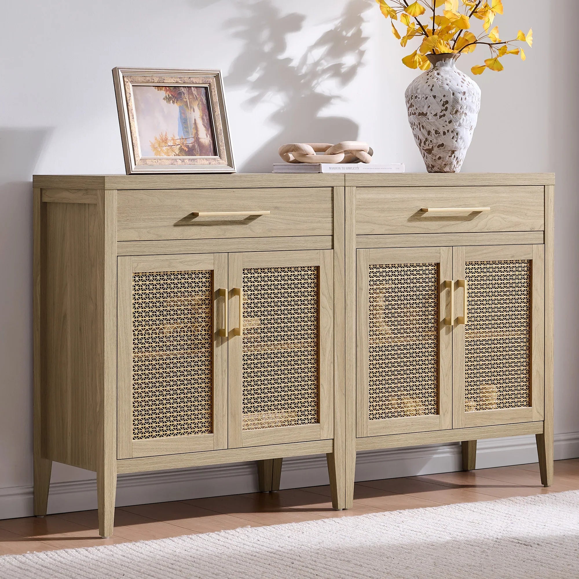 Light wood sideboard with rattan cabinet doors, decorative vase, and framed artwork