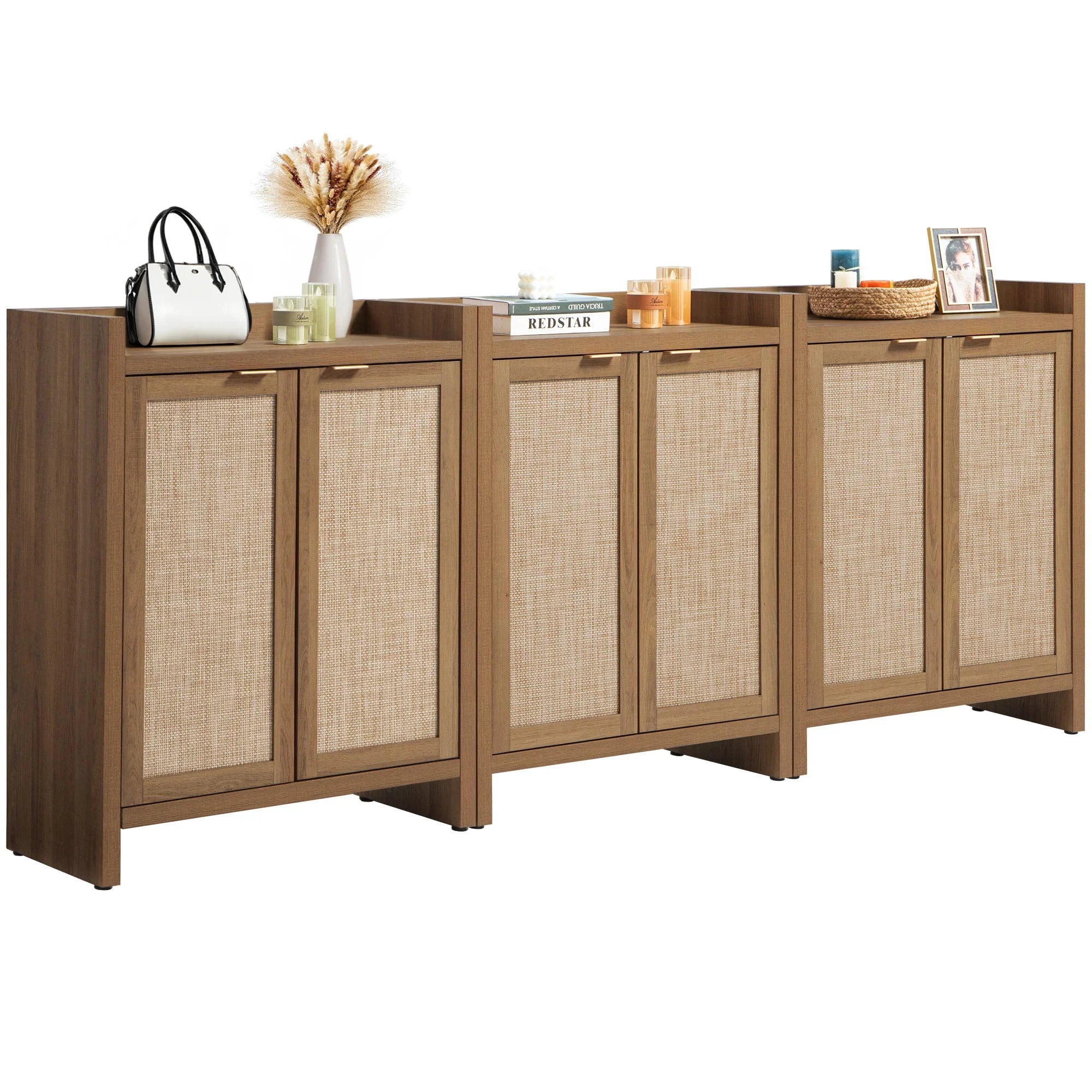 Modern wooden sideboard with rattan cabinet doors, decor, candles, books, and a vase