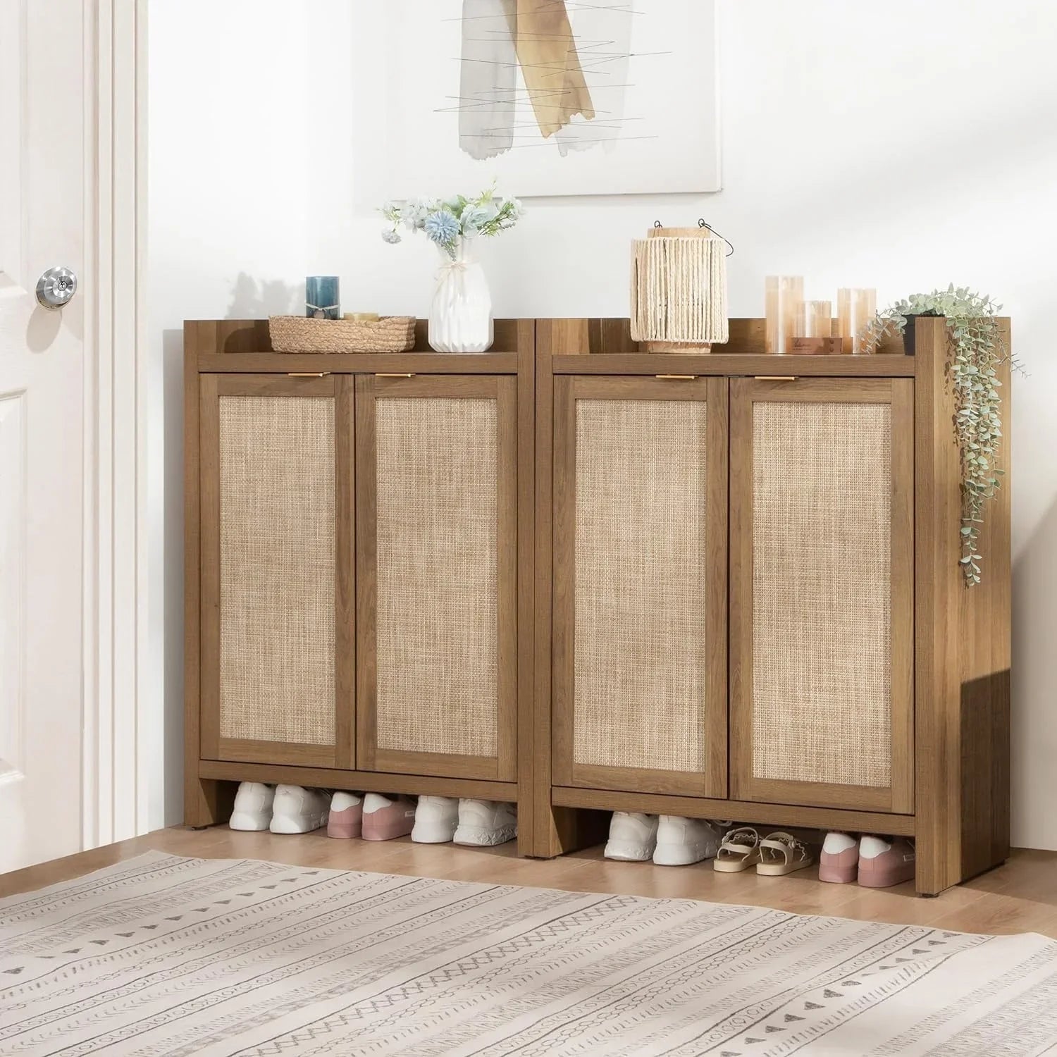 Wooden rattan shoe cabinet with decorative plants, candles, and storage baskets in entryway