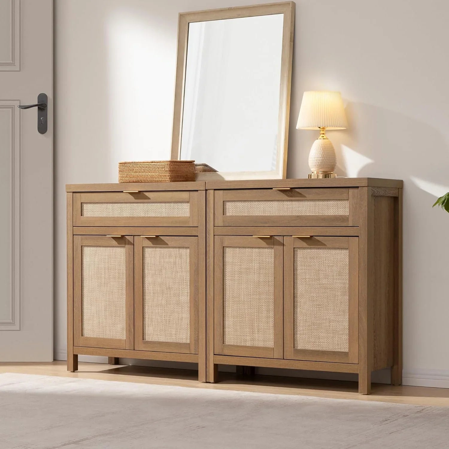 Wooden sideboard with rattan panels, tabletop mirror, basket, and small lamp in a modern room