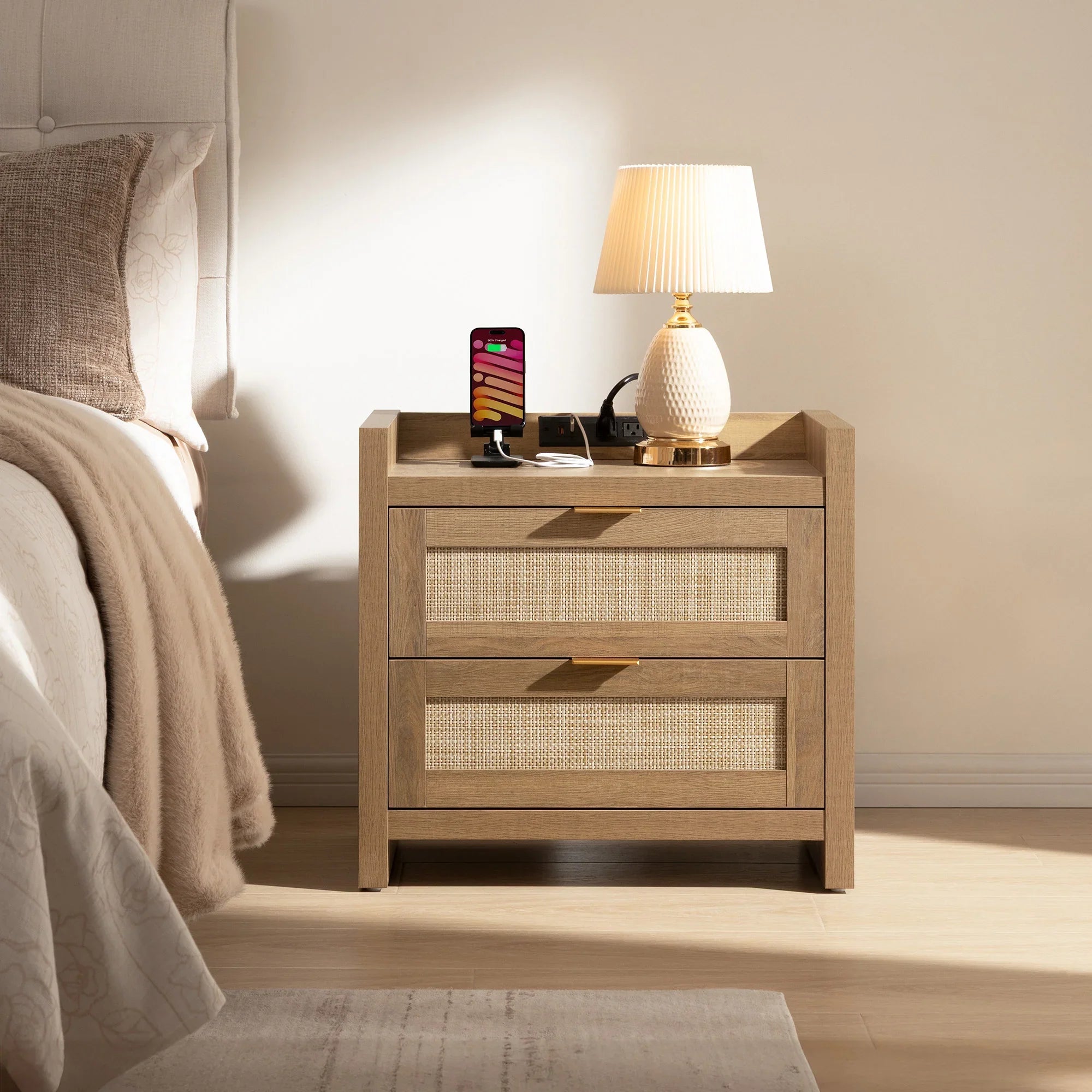 Modern wooden nightstand with lamp and charging phone in cozy bedroom